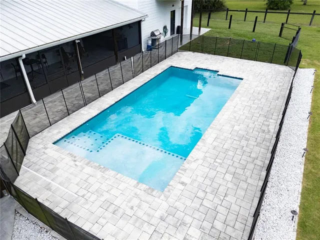 a large white kitchen with a large window and stainless steel appliances
