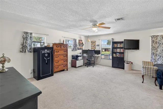 a view of a livingroom with workspace and a window