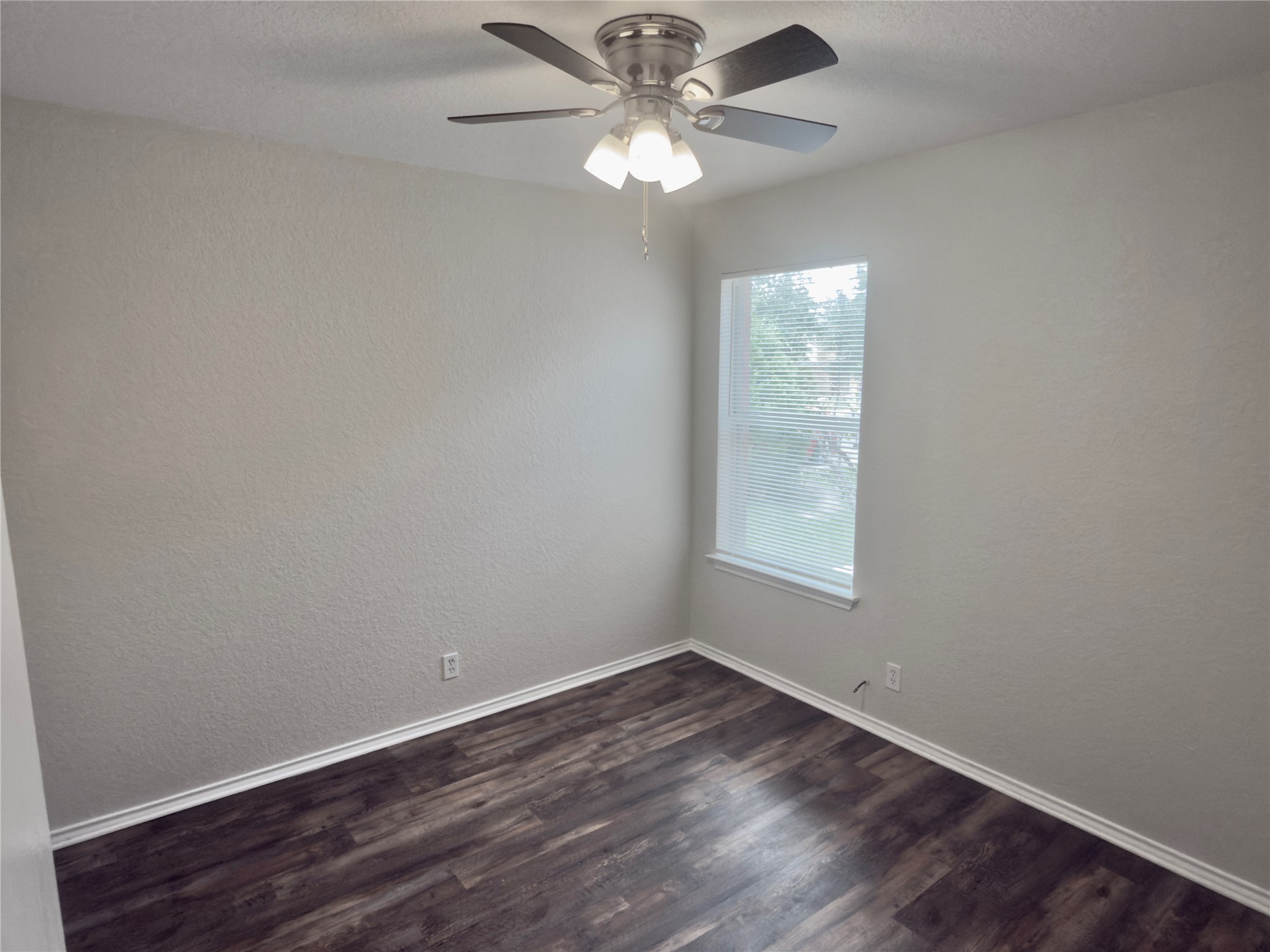 255 Myrtle Street Kyle, TX 78640 - Photo 17 of 31 Room featuring wood-finish flooring, a ceiling fan with integrated lighting, and a single window with blinds