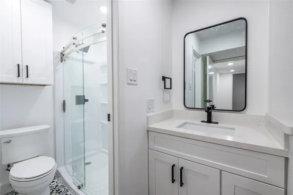 a bathroom with a sink toilet vanity and shower