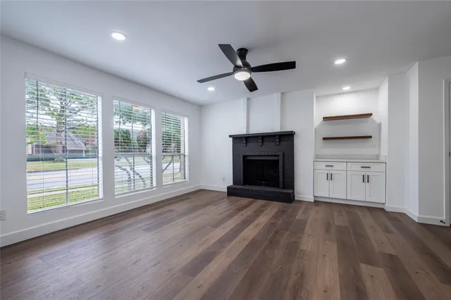 a view of empty room with wooden floor and fireplace