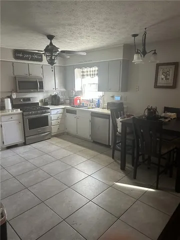 a kitchen with stainless steel appliances wooden floor dining table and chairs