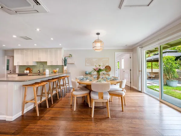 a view of a dining room with furniture a chandelier and wooden floor