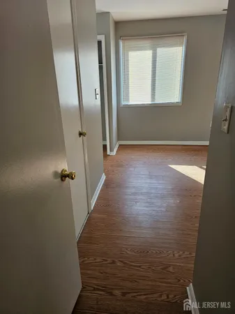 a view of a room with wooden floor and a window