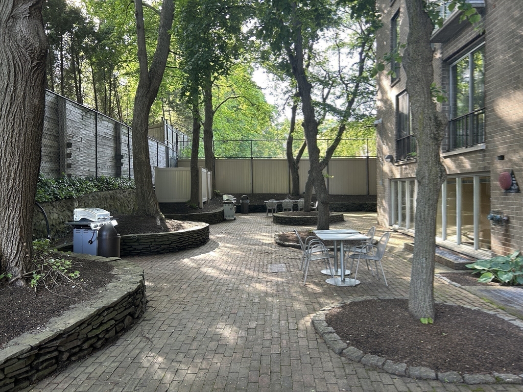 33 Pond Avenue, Unit 401 Brookline, MA 02445 - Photo 12 of 16 a view of a patio with a table and chairs