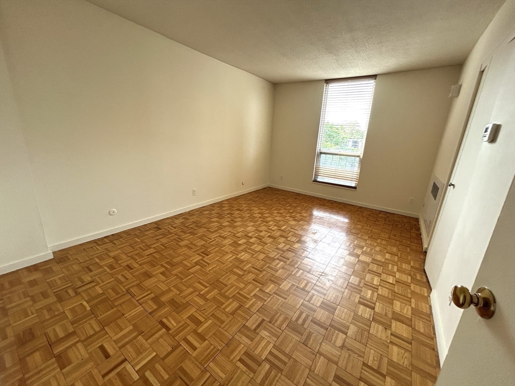 33 Pond Avenue, Unit 401 Brookline, MA 02445 - Photo 4 of 16 a view of empty room with windows