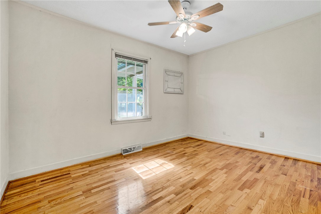 7876 Highway 11 Walhalla, SC 29691 - Photo 22 of 35 Naturally illuminated bedroom features gleaming hardwood flooring and a functional ceiling fan for comfort.