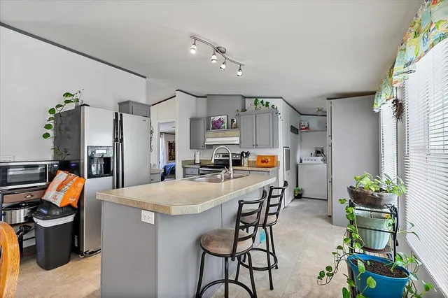 a dining hall with stainless steel appliances a dining table and chairs