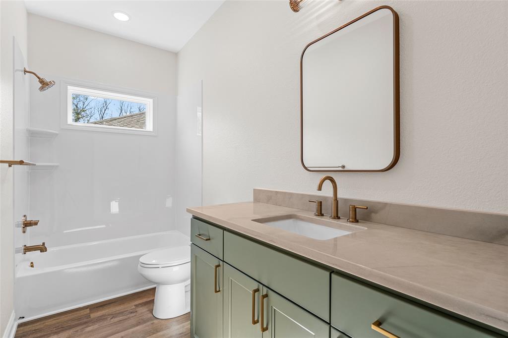 603 South Harrison Street West, TX 76691 - Photo 24 of 30 a bathroom with a granite countertop sink a toilet and a bathtub