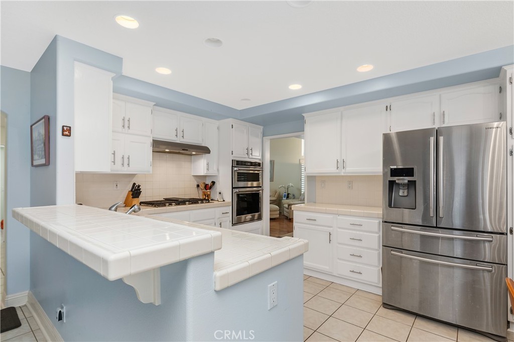 1874 Natalie Lane Riverside, CA 92506 - Photo 18 of 40 a kitchen with white cabinets and stainless steel appliances