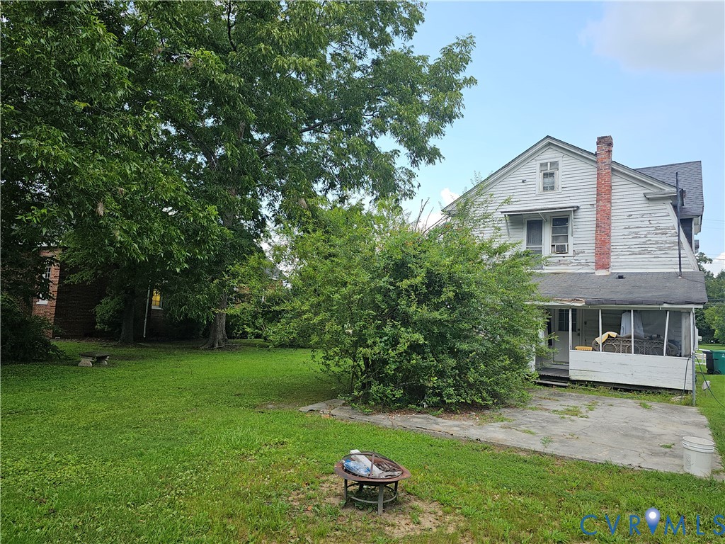 205 East Main Street Waverly, VA 23890 - Photo 4 of 9 a brick house with a big yard and large trees