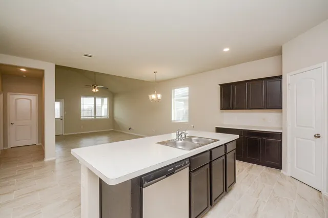 a kitchen with a sink dishwasher a stove and a refrigerator with wooden floor
