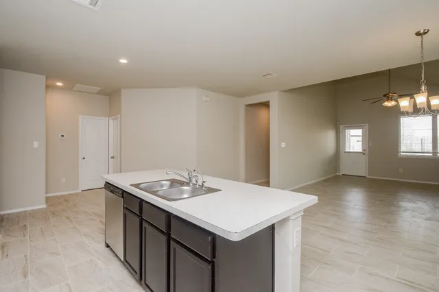 a kitchen with a sink a chandelier cabinets and wooden floor