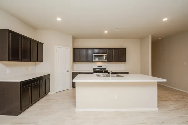 a kitchen with stainless steel appliances granite countertop a sink dishwasher stove top oven and refrigerator