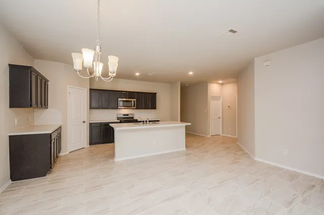 a large kitchen with kitchen island a sink stainless steel appliances and cabinets
