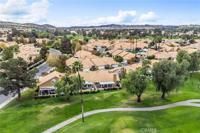 an aerial view of residential houses with outdoor space and trees