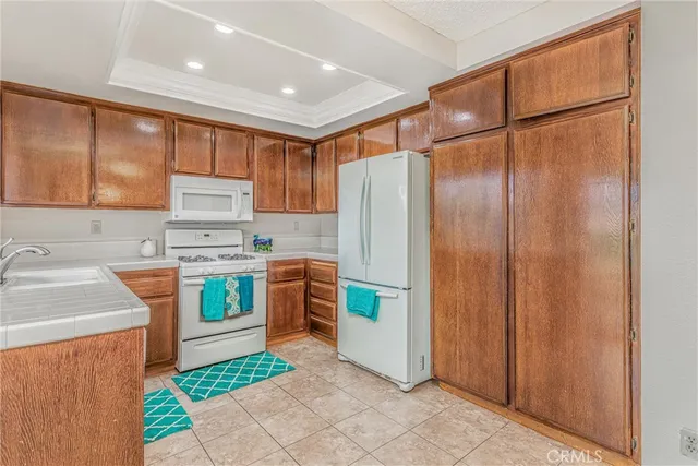 a kitchen with stainless steel appliances granite countertop a refrigerator a sink and a stove