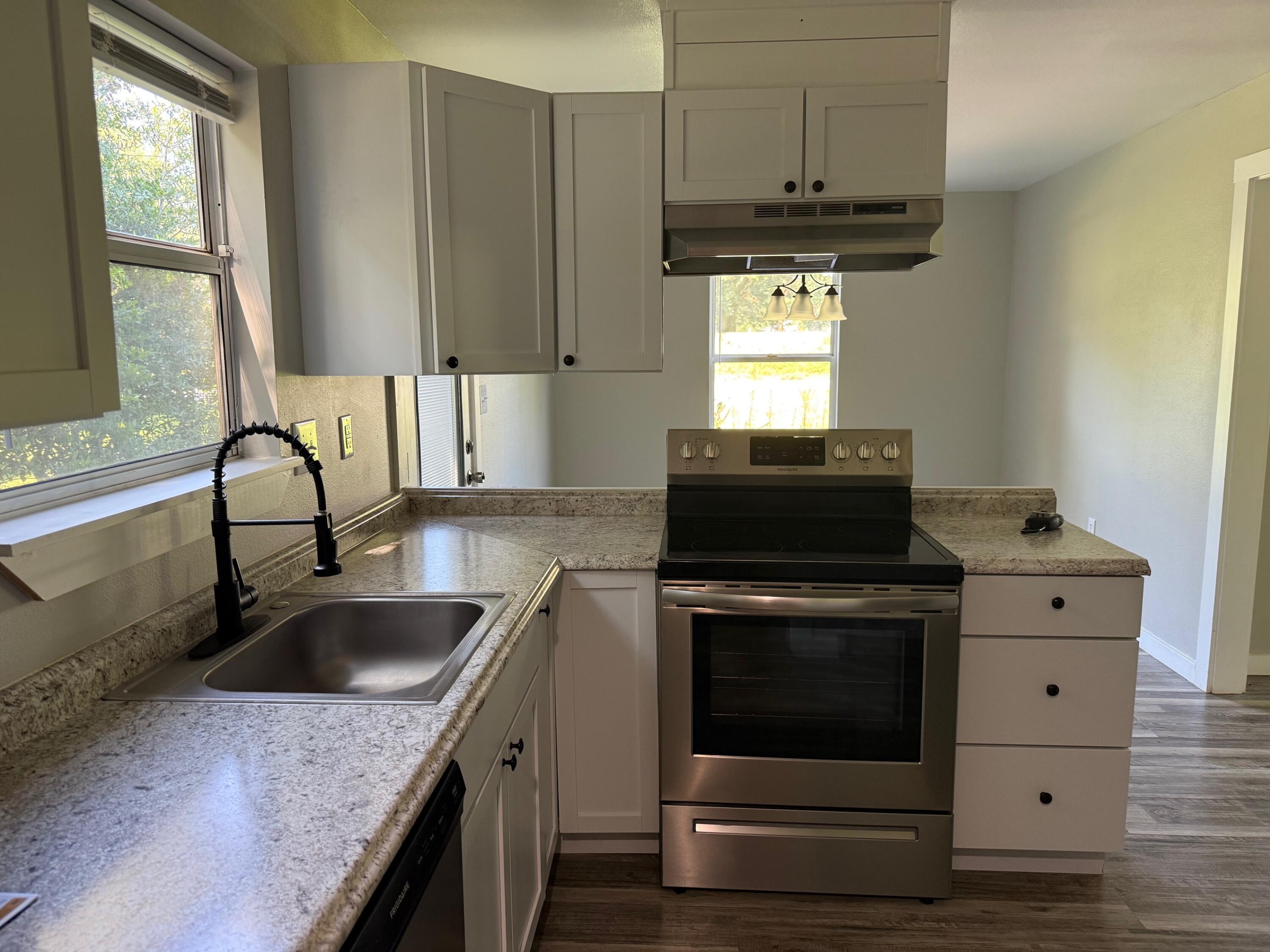5809 Pinecrest Road Crestview, FL 32539 - Photo 2 of 14 a kitchen with granite countertop a stove sink and cabinets