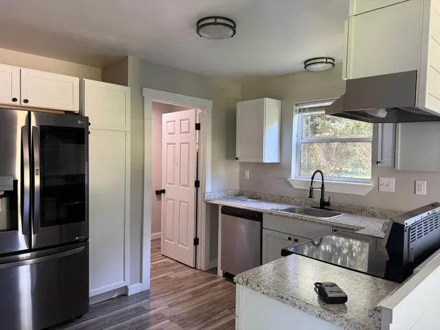 a kitchen with stainless steel appliances granite countertop a refrigerator and a sink