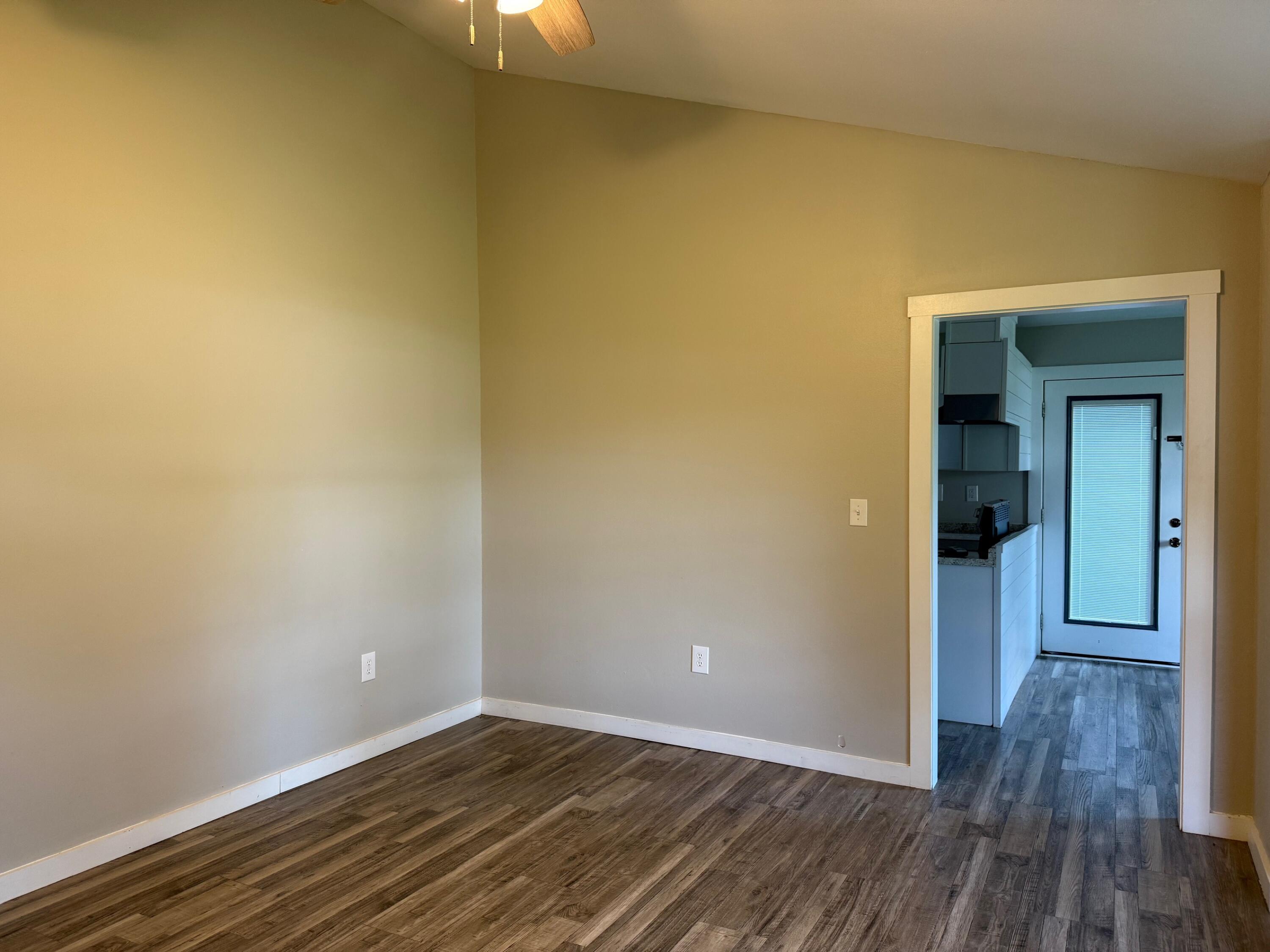 5809 Pinecrest Road Crestview, FL 32539 - Photo 6 of 14 a view of an empty room with wooden floor and a window