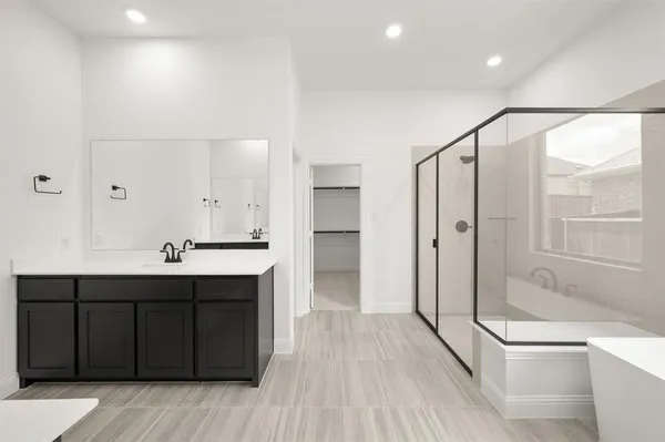 a spacious bathroom with a shower sink and mirror