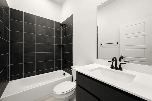 a bathroom with a sink a toilet a window and shower