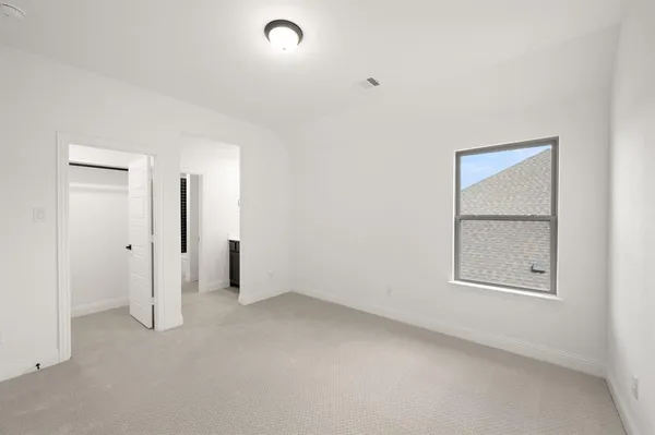 an empty room with a bathroom and a window