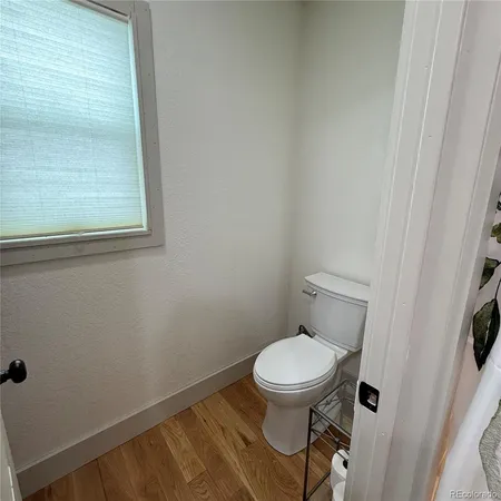 a white toilet sitting next to a small window