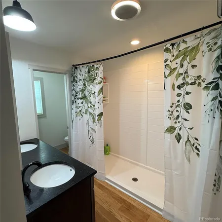 a bathroom with a granite countertop sink toilet a shower and a mirror