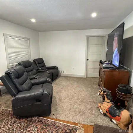 a living room with furniture gym equipment and a flat screen tv