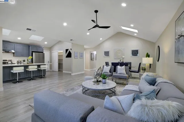 a living room with furniture kitchen view and a dining table with kitchen view