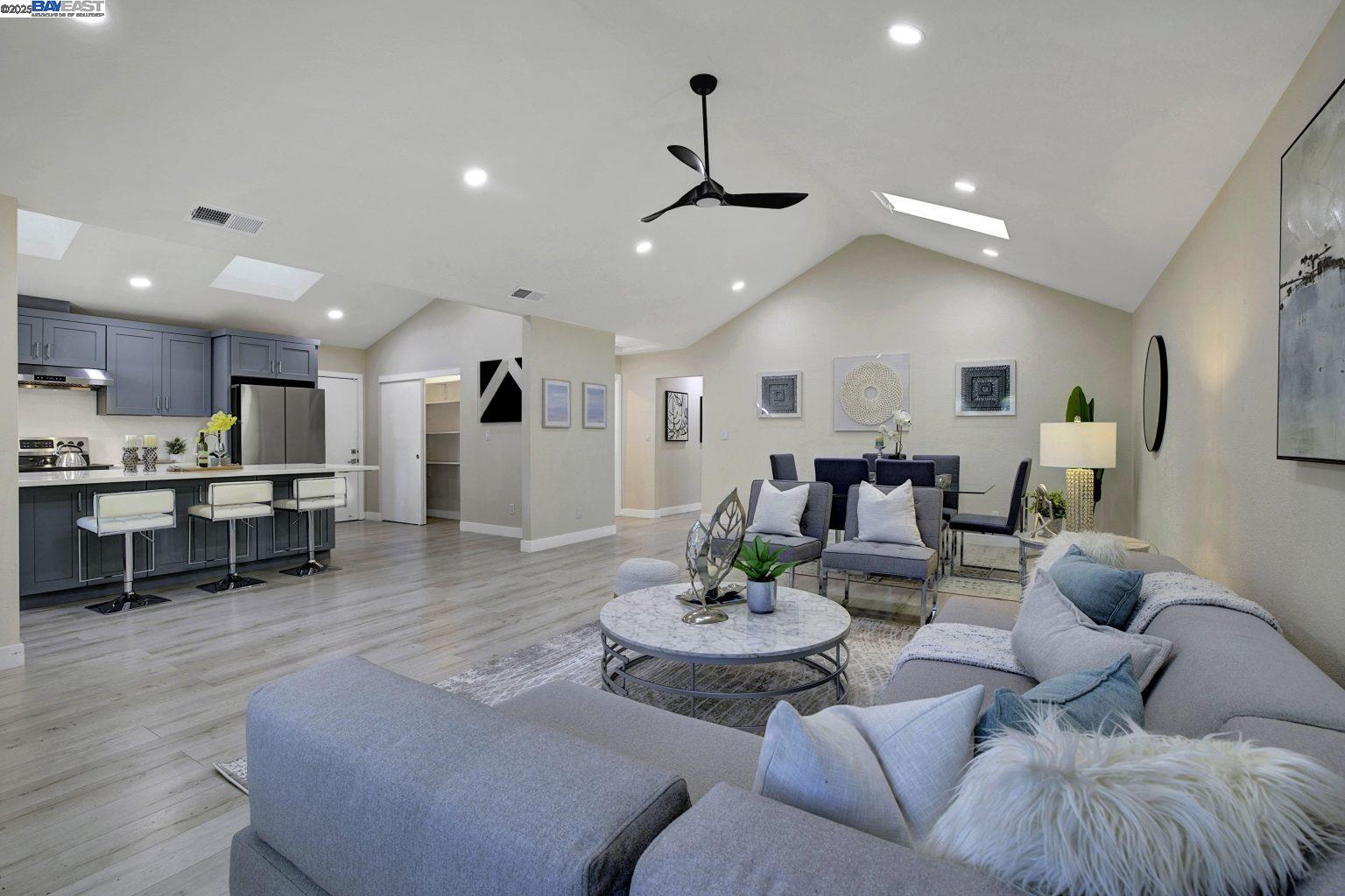 a living room with furniture kitchen view and a dining table with kitchen view