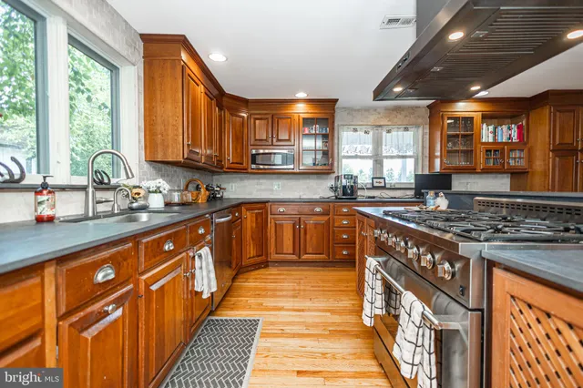 a living room with stainless steel appliances furniture a rug and a kitchen view