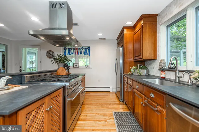a kitchen with stainless steel appliances granite countertop a stove a sink and a refrigerator