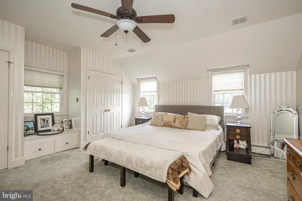 a bedroom with a bed next to a window with a fireplace