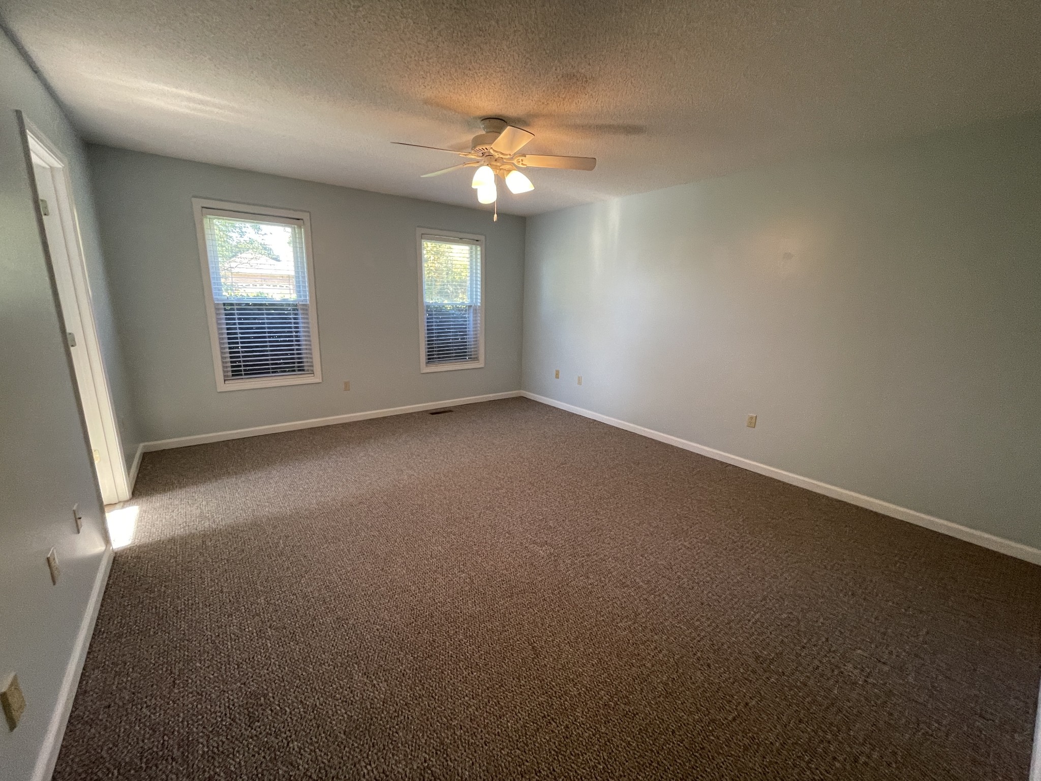 2946 Old Clarksville Sprgfld Road Adams, TN 37010 - Photo 6 of 24 an empty room with windows and chandelier fan