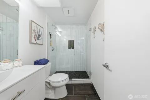 a bathroom with a sink a toilet and shower
