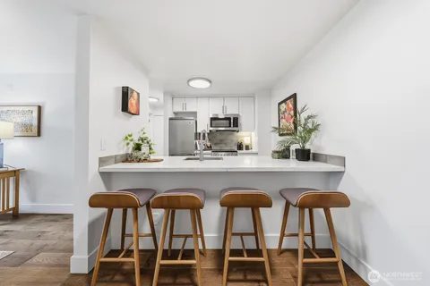 a kitchen with stainless steel appliances granite countertop a dining table and chairs