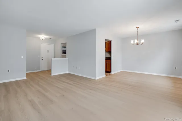 a view of empty room with wooden floor and window