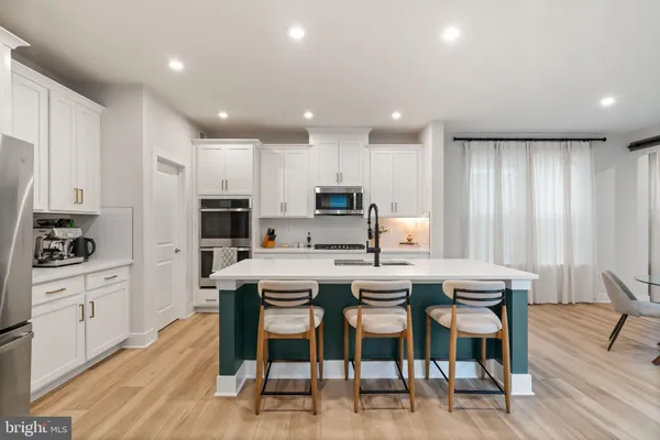 a living room with furniture and a dining table with kitchen view