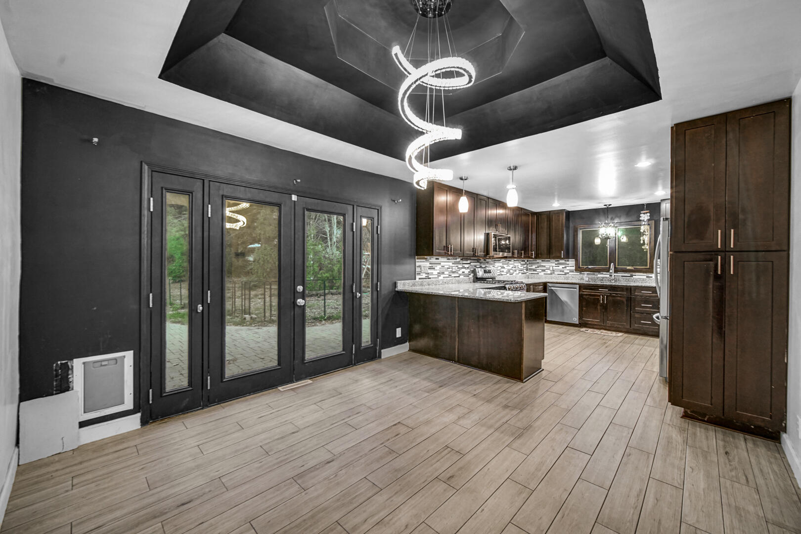 6747 West 450 Road North Michigan City, IN 46360 - Photo 16 of 37 a kitchen with stainless steel appliances kitchen island granite countertop a refrigerator a sink dishwasher a stove and a dining table with wooden floor