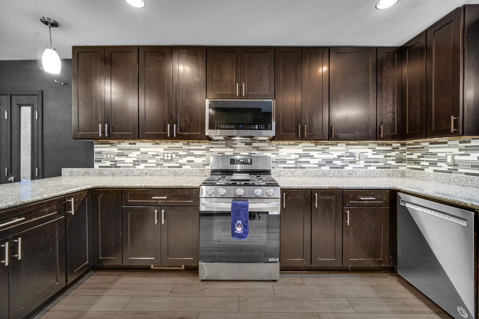 6747 West 450 Road North Michigan City, IN 46360 - Photo 18 of 37 a kitchen with kitchen island granite countertop wooden cabinets and stainless steel appliances