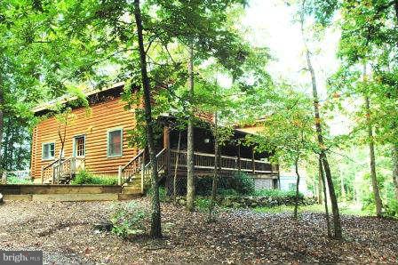 10677 River Road Rixeyville, VA 22737 - Photo 2 of 26 a backyard of a house with lots of plants and large trees