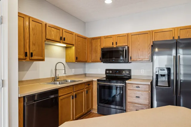 a kitchen with stainless steel appliances a stove sink and refrigerator