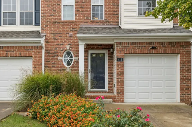 a front view of a house with plants