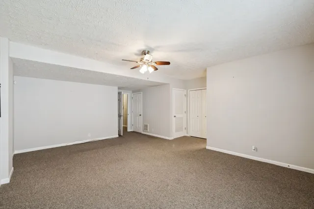 a view of an empty room with a ceiling fan