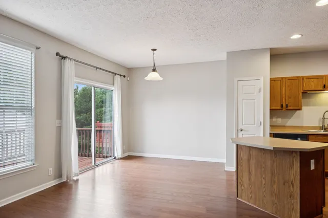 a view of a kitchen with wooden floor and a window