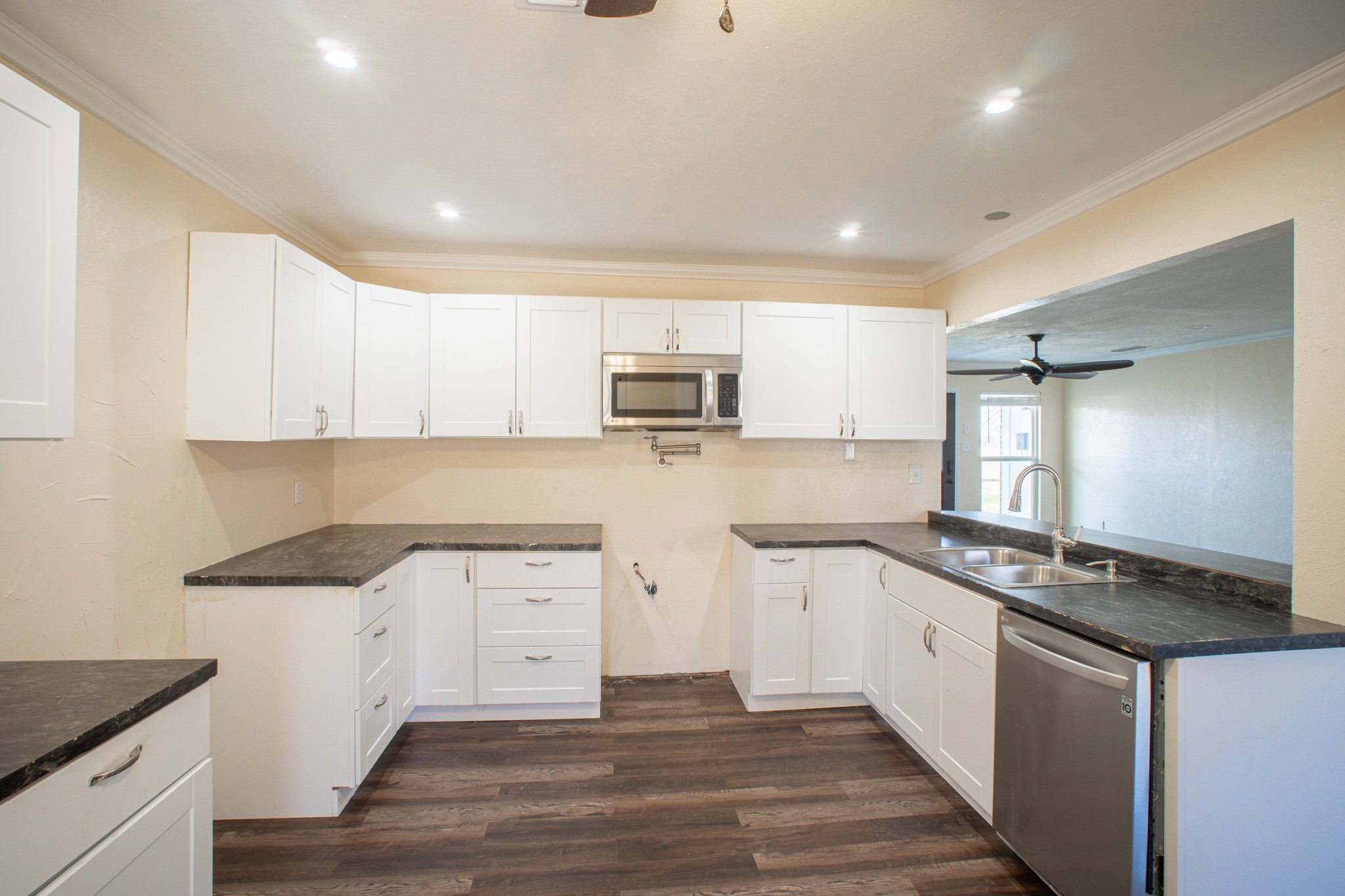 214 North Calhoun Street Groesbeck, TX 76642 - Photo 11 of 20 a kitchen with granite countertop a stove top oven sink and cabinets