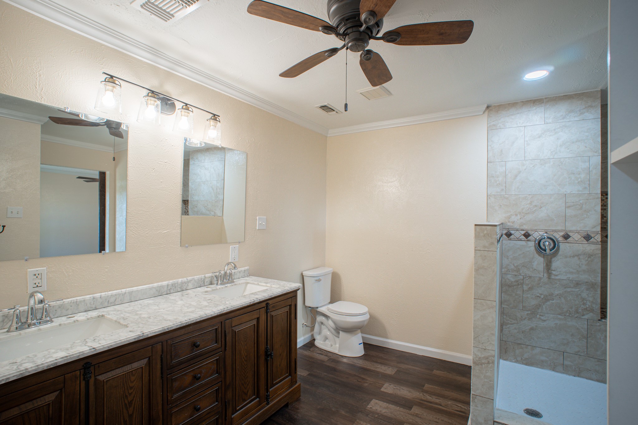 214 North Calhoun Street Groesbeck, TX 76642 - Photo 14 of 20 a bathroom with a granite countertop sink toilet a large mirror a shower and vanity