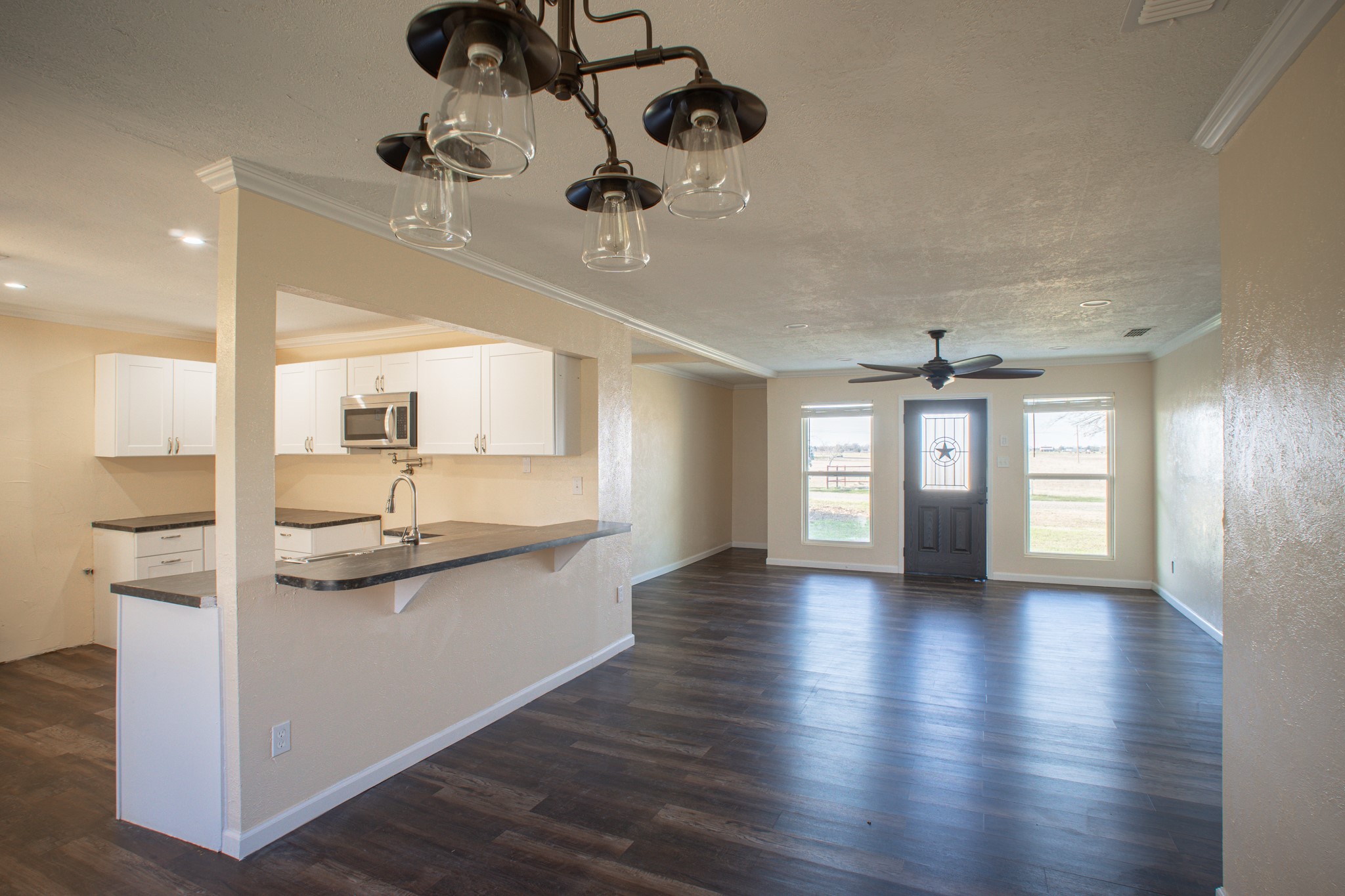 214 North Calhoun Street Groesbeck, TX 76642 - Photo 9 of 20 a kitchen with stainless steel appliances granite countertop a stove and cabinets with wooden floor
